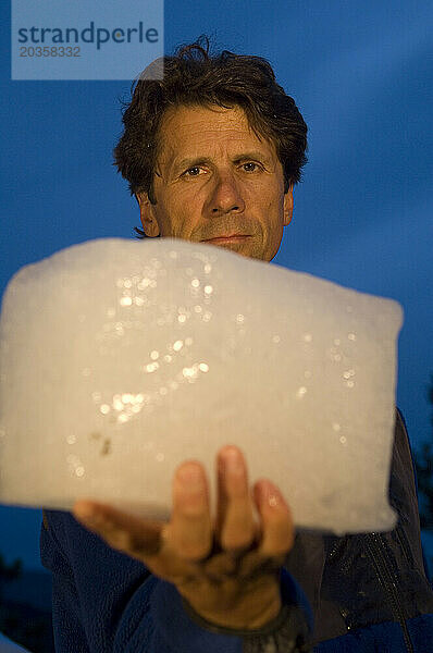 Ein Mann hält in Boulder  Colorado  USA  einen Eisblock in der Hand.