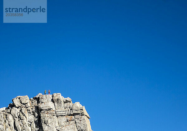 Zwei Menschen stehen auf dem Gipfelblock des Lone Peak in den Wasatch Mountains in Utah