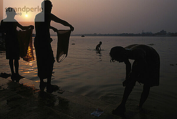 Waschen im Hooghly River bei Sonnenuntergang am Babu Ghat in Kalkutta  Indien. Der Fluss ist heilig  da das Wasser verschmutzt ist.