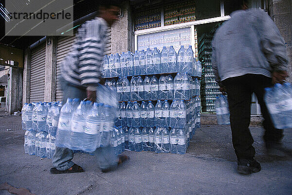 Arbeiter entladen Trinkwasserflaschen in einem Geschäft in Amman  Jordanien.