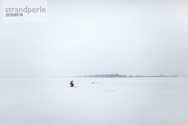 Ein französisch-kanadischer Eisfischer steht auf dem zugefrorenen Moses Lake in Moses Lake  Washington