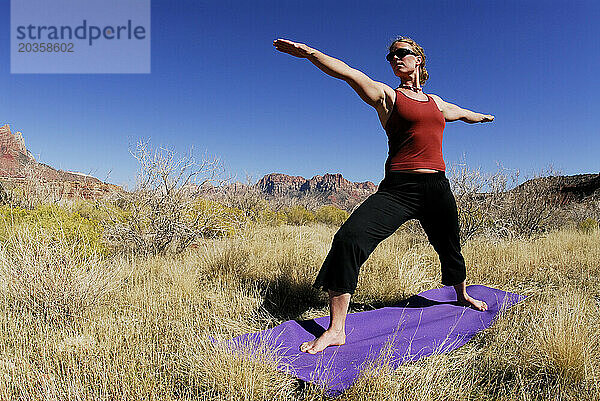 Eine Frau macht Yoga draußen in Springdale  Utah.