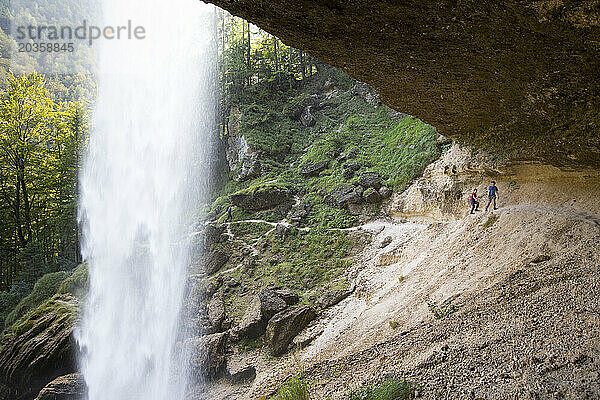 Zwei Personen gehen über den Pfad hinter dem Pericnik-Wasserfall im alpinen Vrata-Tal in der Nähe von Mojstrana im Nationalpark Triglav  Slowenien