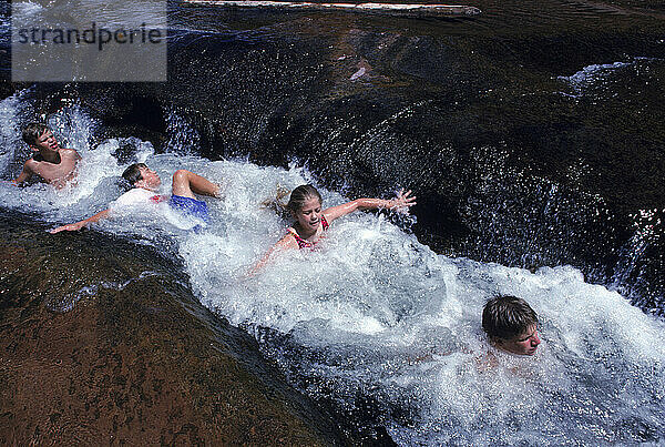 Menschen planschen auf der natürlichen Wasserrutsche Slide Rock in Sedona  Arizona.