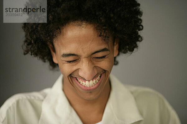 Afroamerikanischer Mann lächelt und lacht.