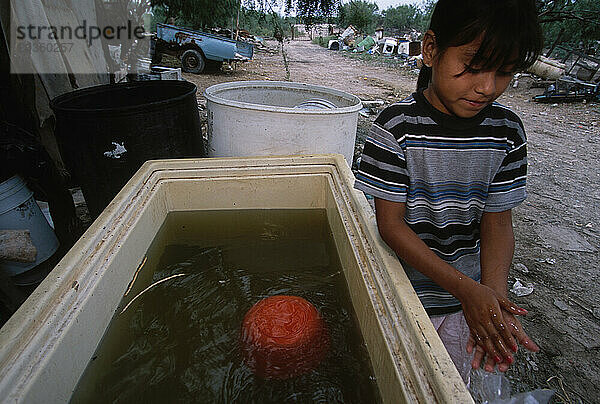 Eine 13-köpfige Familie  die in einem Haus in Reynosa  Mexiko  lebt und zum Waschen Wasser aus einem Kanal in der Nähe ihres Hauses bezieht. Jeden Tag müssen sie ein 200-Liter-Fass damit auffüllen
