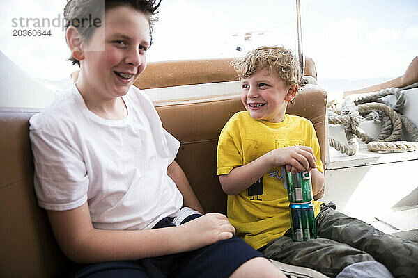 Junge Brüder lachen zusammen  während sie auf einer Karibikfähre sitzen