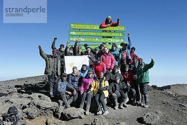 Eine Gruppe Wanderer posiert für ein Foto auf dem Gipfel des Kilimandscharo.