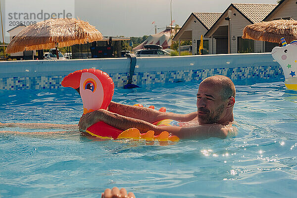 Ein Mann schwimmt glücklich in einem Pool