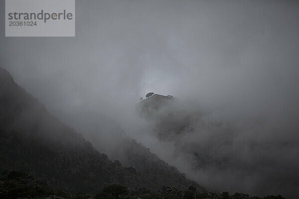 Nebel bedeckt die Berge in Villaluenga del Rosario  Naturpark Sierra de Grazalema  Provinz Cádiz  Andalusien  Spanien