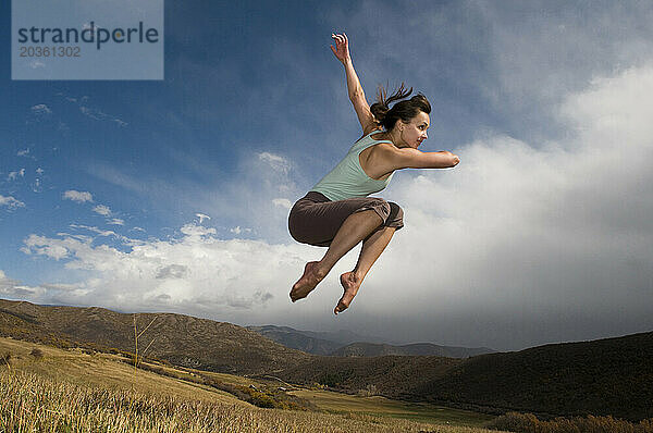 Eine Frau springt in den Bergen von Old Snowmass  Colorado.