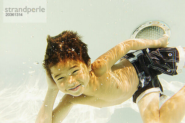 Ein kleiner Junge taucht unter Wasser.