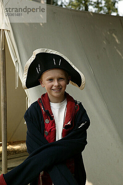 Ein junger kaukasischer Junge kleidet sich an einer historischen Stätte im Süden in Bürgerkriegskleidung.