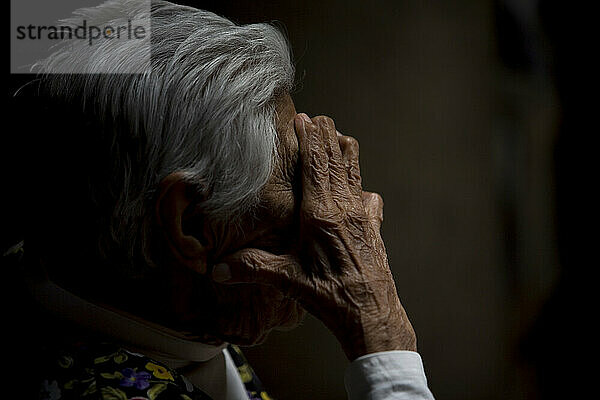 Eine ältere Frau schützt ihr Gesicht vor der Sonne im Seniorenheim Unserer Lieben Frau von Guadalupe in Mexiko-Stadt