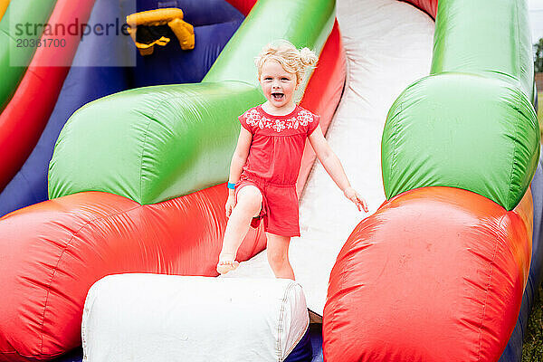 Glückliches Kind auf aufblasbarer Hüpfburg beim Festival