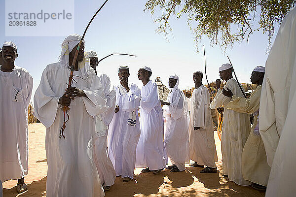 Junge Männer des Stammes Darhammid tanzen im Dorf Limrat  Nordkordofan  Sudan  während einer Hochzeitsfeier. Sie erhöhen