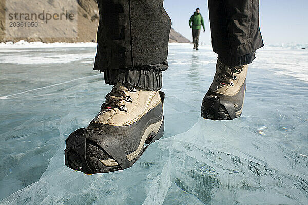 Zwei Menschen wandern im Winter auf dem zugefrorenen Baikalsee in Sibirien  Russland.