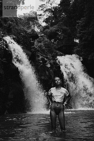 Reisende Frau auf einem Abenteuer an einem tropischen Wasserfall auf Bali.