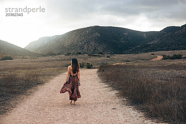 Frau in Kleid geht den Wanderweg in San Diego entlang