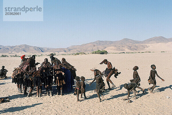 Frau und Kinder singen in der Wüste  Namibia.