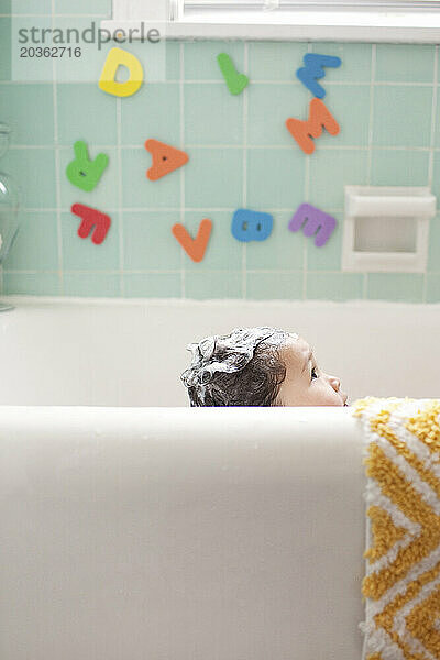 Ein junges asiatisch-amerikanisches Mädchen mit seifigen Haaren in der Badewanne  30. Januar 2011.