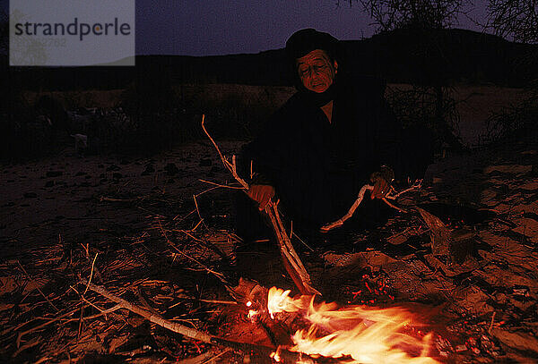 Ein Mitglied eines Tuareg-Clans bereitet in der Sehal-Wüste in Mali  Westafrika  ein Feuer vor.