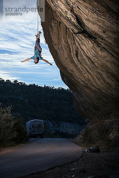 Vorderansicht eines Profis  der bei Sonnenuntergang auf einem Felsen klettert  Margalef  Katalonien  Spanien