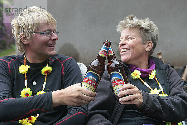 Zwei Wanderer trinken Bier  um ihre erfolgreiche Besteigung des Kilimandscharo zu feiern.
