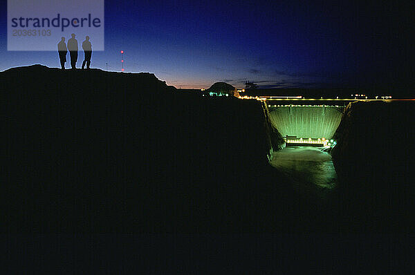Eine Gruppe von Menschen genießt die nächtliche Aussicht auf den Glen Canyon Dam am Colorado River.