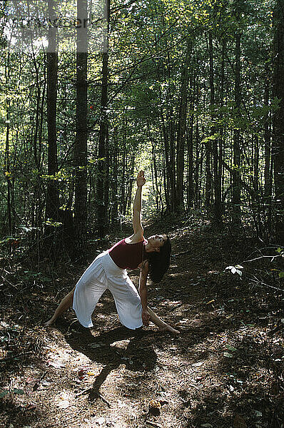 Eine Frau praktiziert Yoga im Wald  North Carolina  USA.