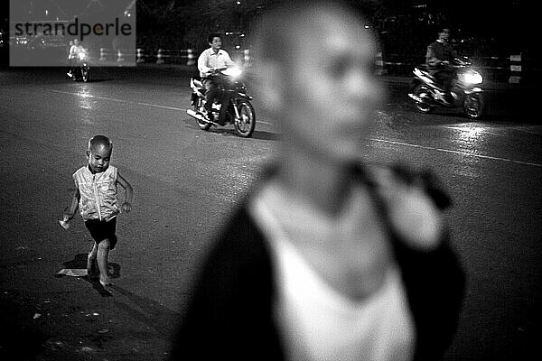 Son runs to catch mother in street  in Hanoi  Vietnam.