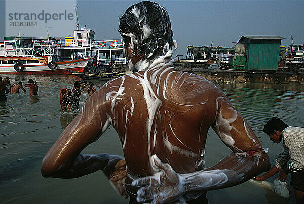 Männer waschen sich im Hooghly River am Babu Ghat in Kalkutta  Indien. Der Fluss ist heilig  da das Wasser verschmutzt ist.