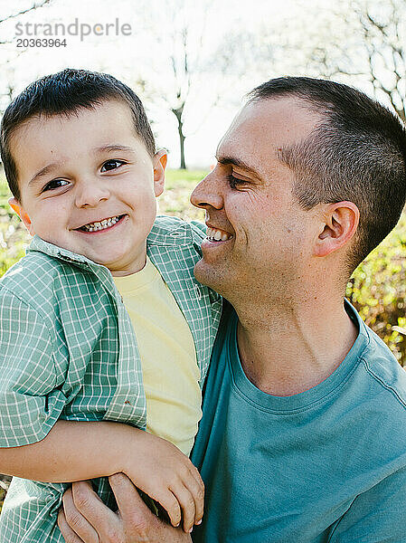 Vater und Sohn lachen und lächeln gemeinsam im Sonnenschein