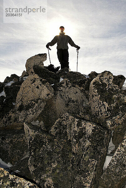 Ein Mann mit Skistöcken steht auf einem Felsen in Argentinien