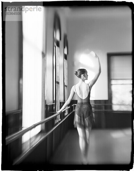 Eine junge kaukasische Balletttänzerin übt eine ruhige Pose. (Polaroid)