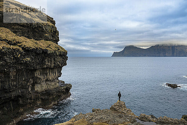 Mann steht am Meeresufer  Färöer-Inseln  Dänemark