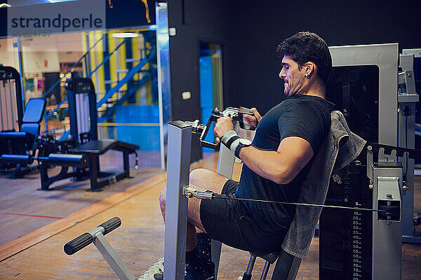 Konzentrierter Mann macht Kraftübungen im Fitnessstudio