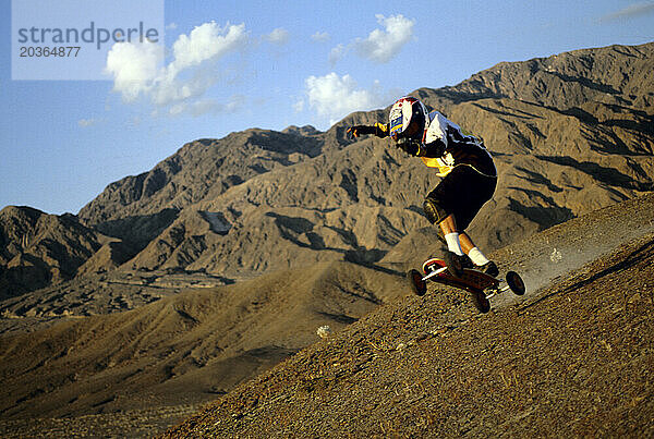 Ein junger Mann fährt auf seinem Mountainboard im Death Valley  Kalifornien.