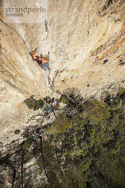 Mann klettert eine schwierige Route auf Kalkstein auf Mallorca  Spanien.