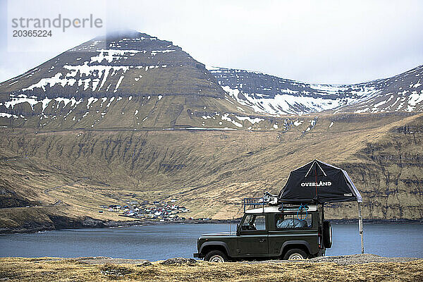 4x4-Auto mit Zelt gegen Berge geparkt  Färöer-Inseln  Dänemark