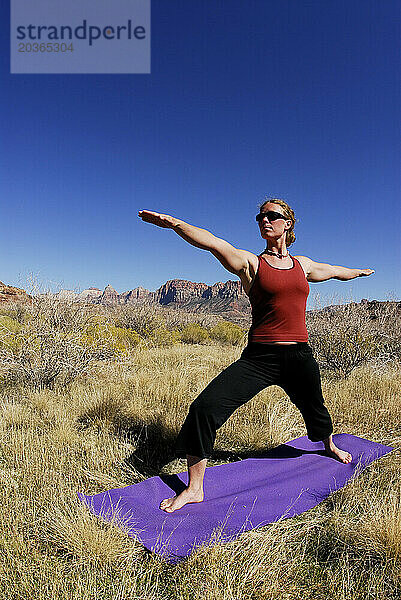 Eine Frau macht Yoga draußen in Springdale  Utah.