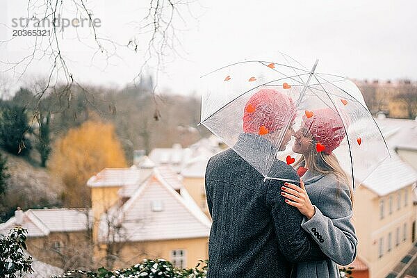 Junges Paar spaziert mit Regenschirmherz durch Prag