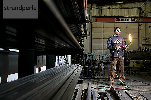 Ein Spezialschweißer zündet in einer Metallwerkstatt einen Schneidbrenner an. Louisville  CO