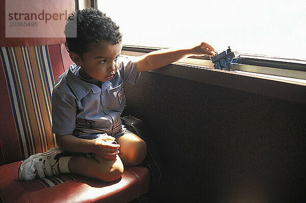 A boy playing with a toy train.