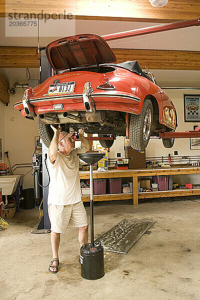 Ein Mann arbeitet in seiner Garage in Pennsylvania an seinem antiken Sportwagen.