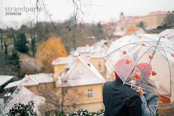 Junges Paar spaziert mit Regenschirmherz durch Prag