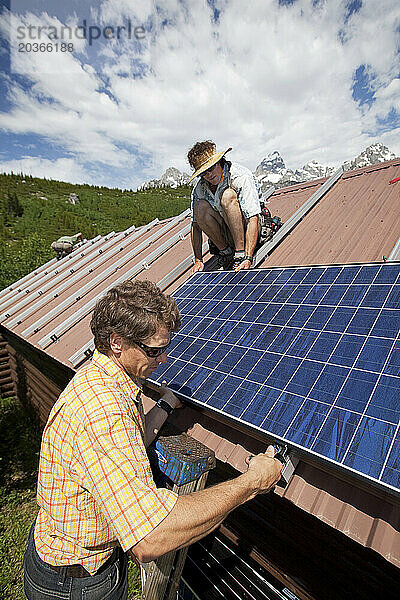 Zwei Personen führen die Installation einer Photovoltaikanlage auf der Grand Teton National Park Climber's Ranch in Wyoming durch