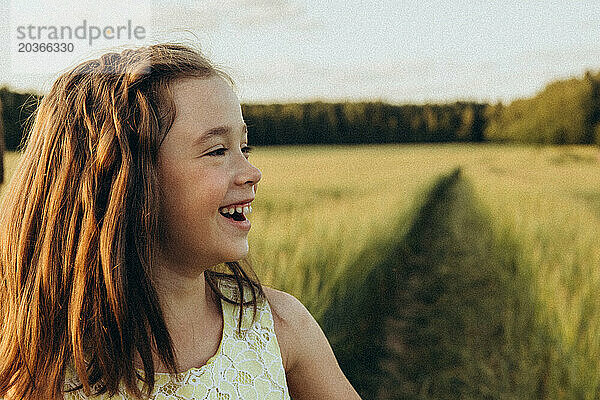 Porträt eines lachenden Mädchens in einem Weizenfeld