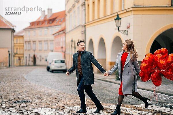 Junges Paar geht mit Luftballons im Herzen durch Prag