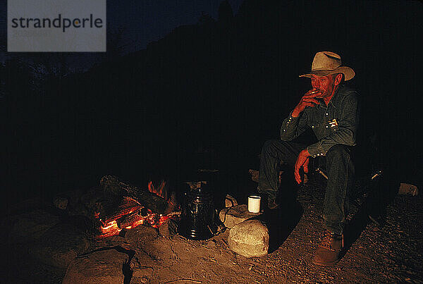 Ein Cowboy entspannt nachts  Arizona  USA.